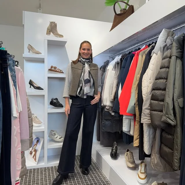 A layered neutral outfit with a scarf, gilet and striped sleeves at Shaw’s